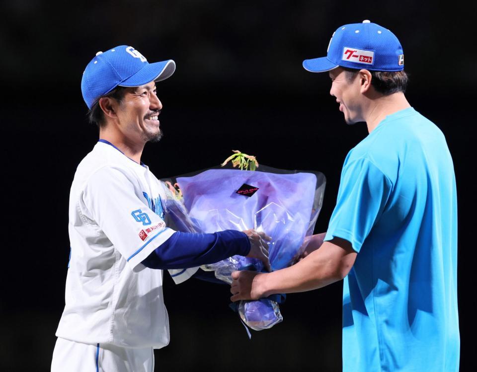 　大野（右）から花束を受け取る祖父江（撮影・立川洋一郎）
