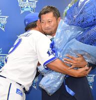 　引退会見後のサプライズで山崎（左）から花束を受け取りハグをする森唯（撮影・開出牧）