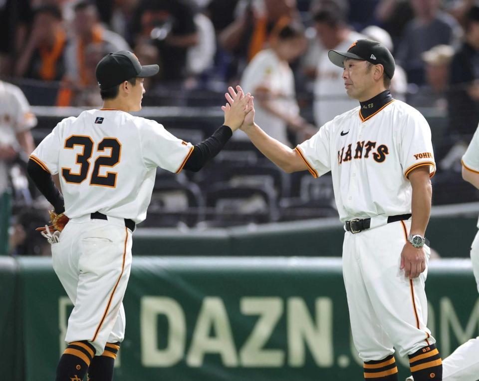 　広島に連勝し、浦田（左）とタッチを交わす阿部監督