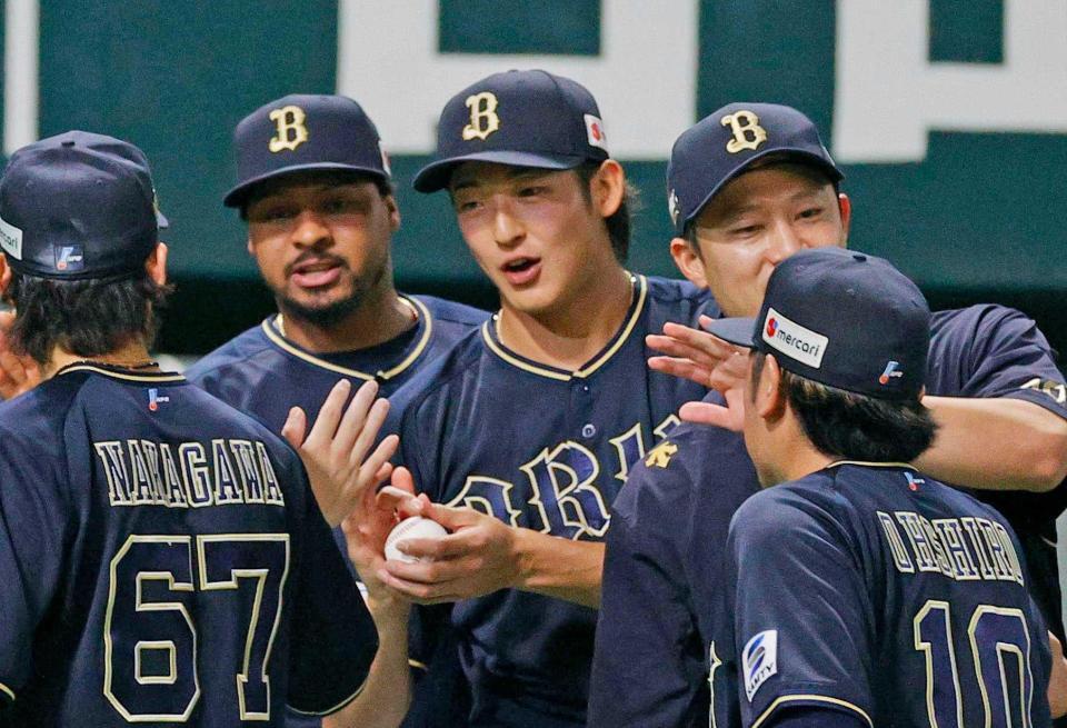 　８回途中のピンチで登板し、好救援で２勝目を挙げウイニングボールを受け取る山崎（中央）