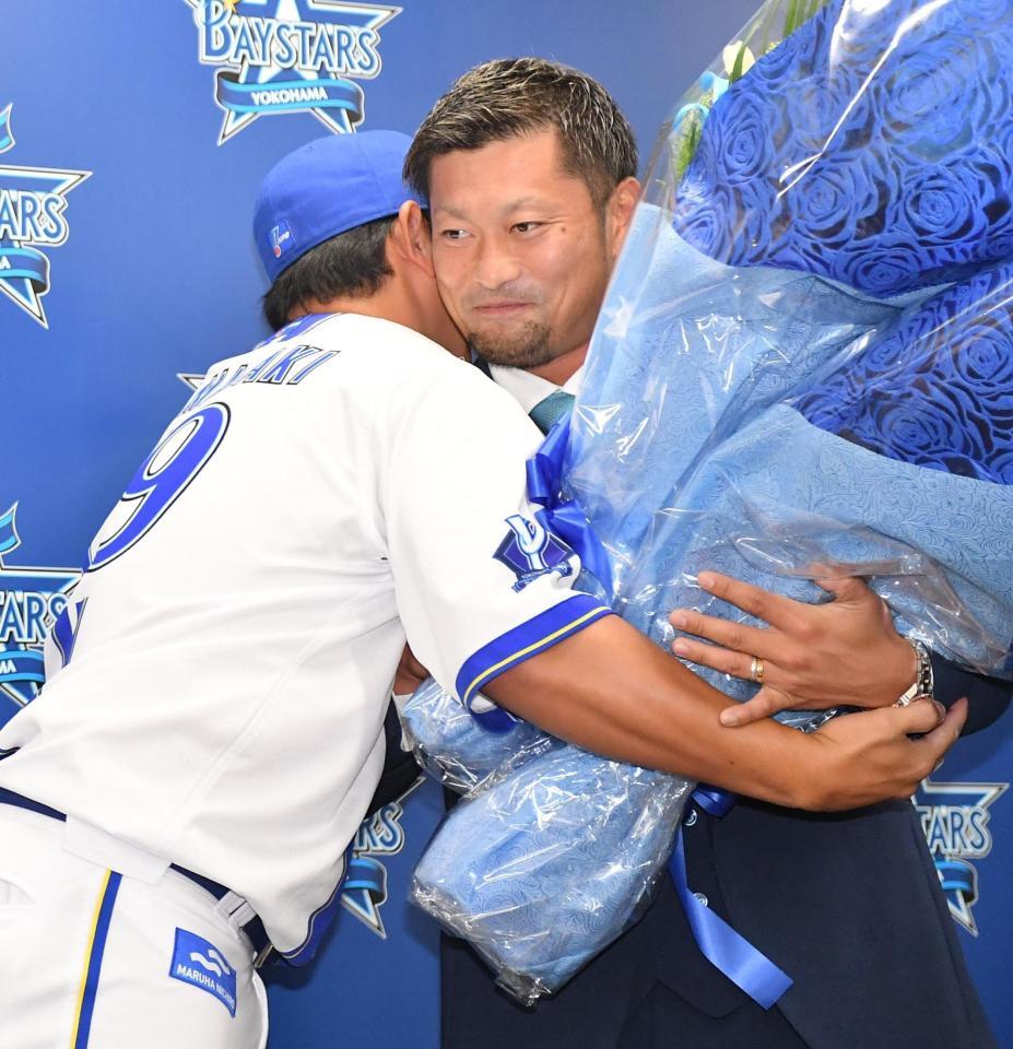 　引退会見後のサプライズで山崎（左）から花束を受け取りハグをする森唯（撮影・開出牧）