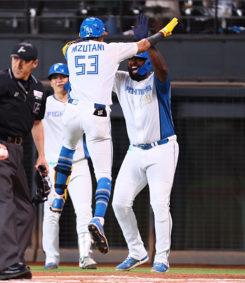 　１回、先制２ランを放った水谷（５３）を迎えるレイエス（右）＝撮影・中島達哉