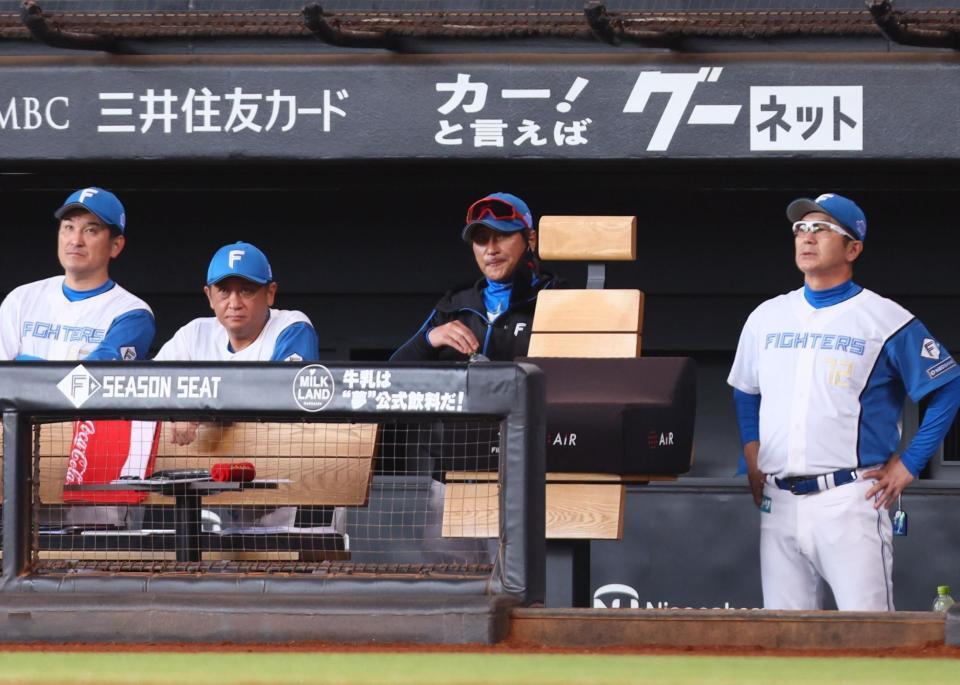 　２回、厳しい表情で水分補給しながら戦況を見つめる新庄監督（中央）＝撮影・中島達哉