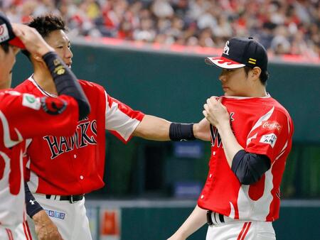 ８回に登板し、１失点で投げ終えた松本裕（右）を迎えるソフトバンク・柳田＝みずほペイペイドーム