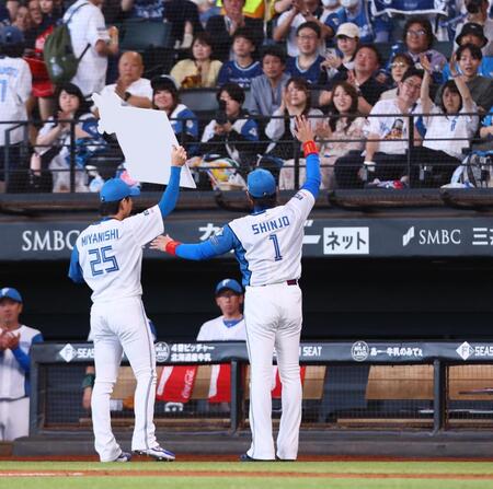 　５回、９００試合登板を達成し、スタンドのファンに記念ボードを掲げる宮西（２５）と新庄監督（撮影・中島達哉）