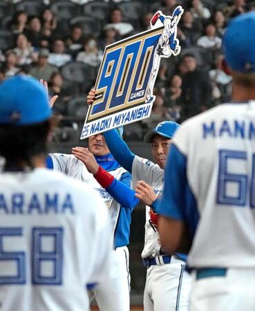 　通算９００試合登板を達成し、記念のボードを掲げる宮西