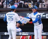 　５回、９００試合登板を達成した宮西（２５）に記念ボードを手渡す新庄監督（撮影・中島達哉）