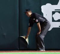 　２回、栗原の打球を追った広岡がフェンスに激突し、穴の開いた部分を補修する審判