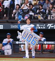 　５回、９００試合登板を達成し、記念ボードを手にスタンドのファンの歓声に応える宮西（撮影・中島達哉）