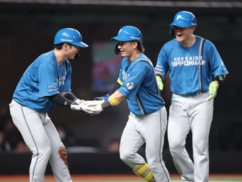 　５回、３ランを放ち、ナインとタッチを交わす水野（中央）＝撮影・西岡正