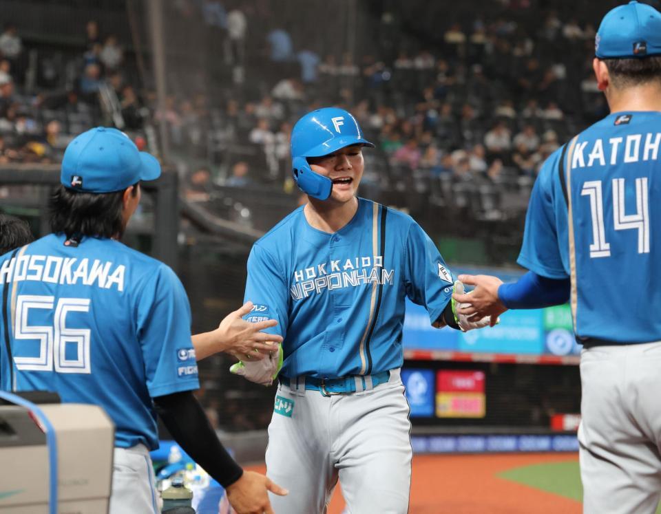 　２回、田宮の適時打で生還し、ナインとタッチを交わす清宮幸（撮影・西岡正）