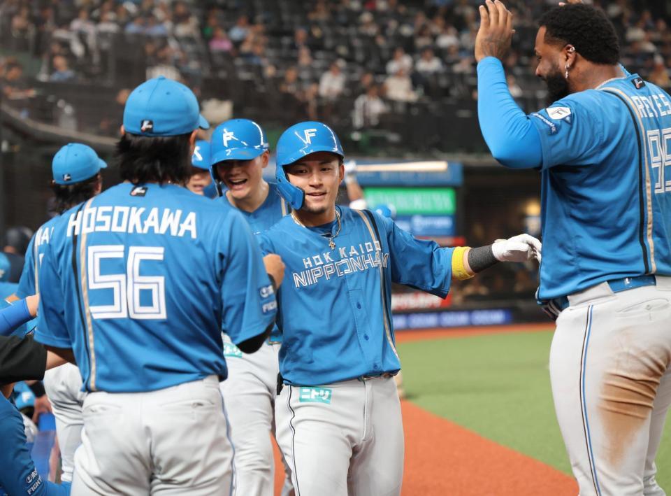 　５回、３ランを放ち、ナインとタッチを交わす水野（中央）＝撮影・西岡正