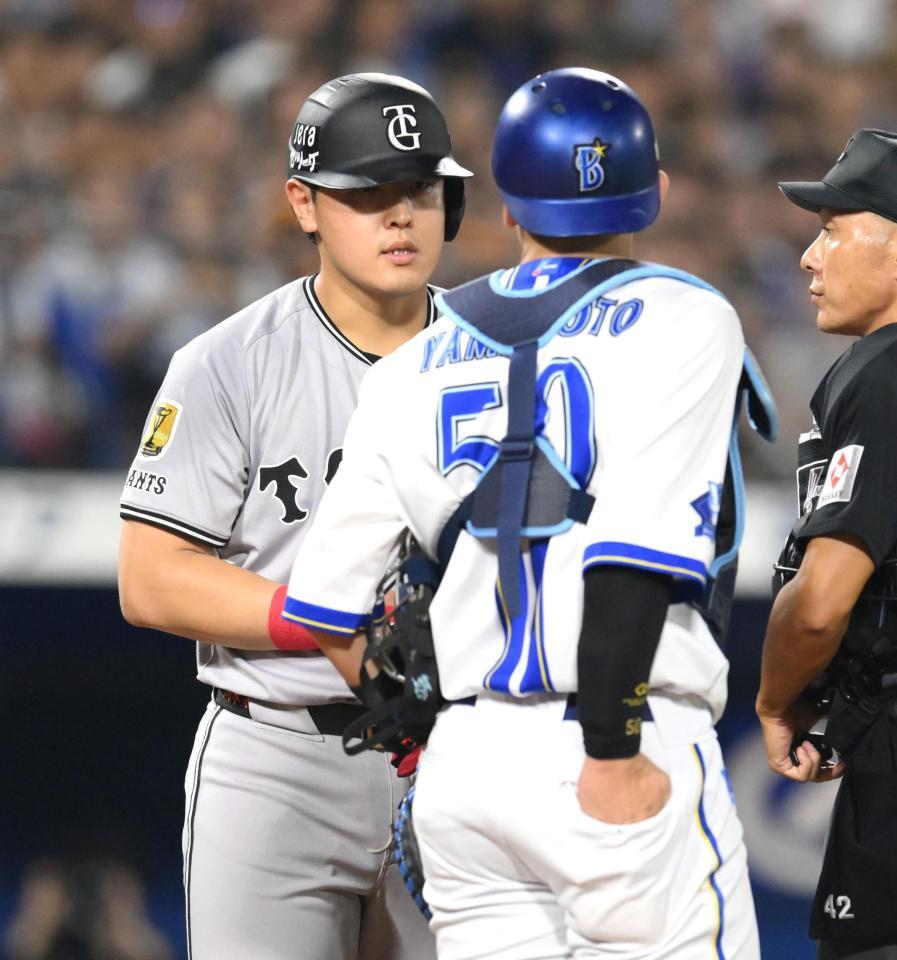 　９回、死球を受け、山本（奥）と会話を交わす岡本（撮影・伊藤笙子）