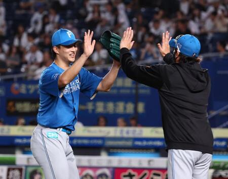 　プロ初完封勝利をあげ、新庄監督（右）とタッチを交わす達（撮影・中島達哉）