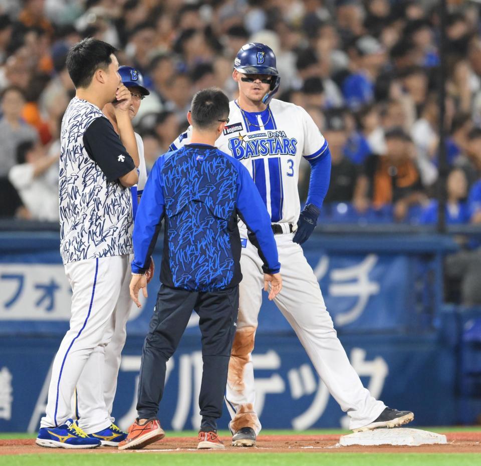 　巨人戦の７回、三塁の判定を巡るリプレー検証中、トレーナーらと話し込むオースティン（奥）＝２６日