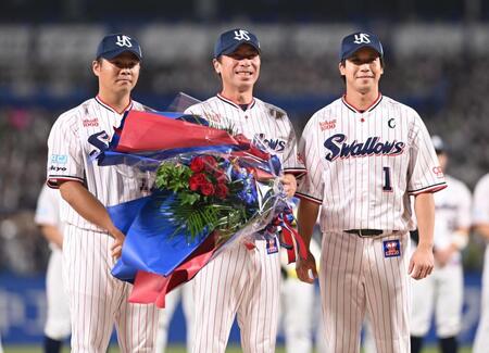 　花束を受け取り笑顔の高津監督（中央）。左は選手会長の清水、右はキャプテンの山田（撮影・開出牧）