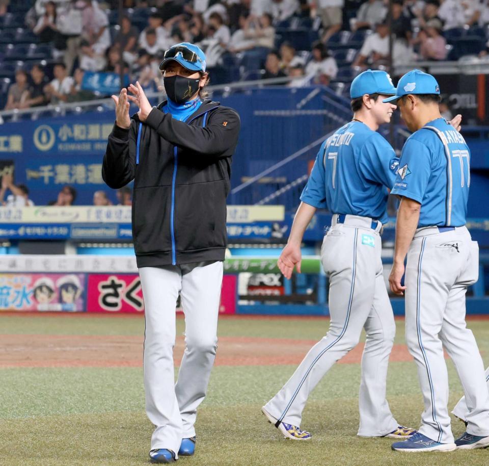 　ナインを迎えた後、拍手する新庄監督（左）