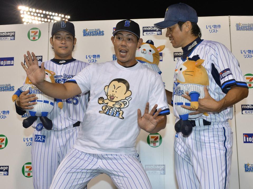 　筒香嘉智（左）、三浦大輔（右）とお立ち台に立ち、通算１００セーブ達成記念Ｔシャツ姿でポーズを決めるＤｅＮＡ・山口俊（横浜、２０１２年９月）