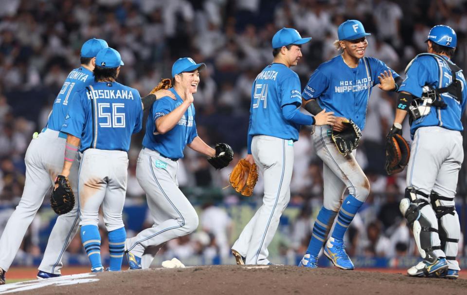 　ロッテに勝利をあげ、タッチを交わす日本ハムナイン（撮影・中島達哉）