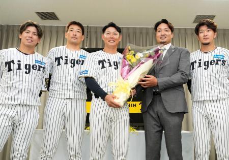 　現役引退の記者会見で、記念写真に納まる阪神の原口文仁内野手（中央）ら＝３０日、兵庫県西宮市