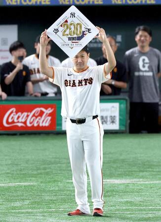 　日米通算２００勝を達成し、ボードを掲げる田中将