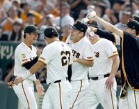 　日米通算２００勝を挙げ、ナインに祝福される田中将（中央）