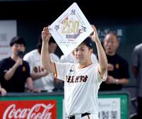 　日米通算２００勝を達成し、ボードを掲げる田中将