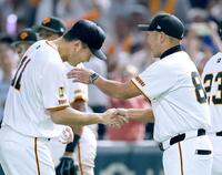 　日米通算２００勝を挙げ、阿部監督（右）と握手を交わす田中将