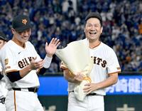 　日米通算２００勝を達成し、坂本（左）から花束を受け取った田中将