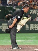 　試合後、花束を受け取り、一礼する笠原昌春審判員（撮影・伊藤笙子）