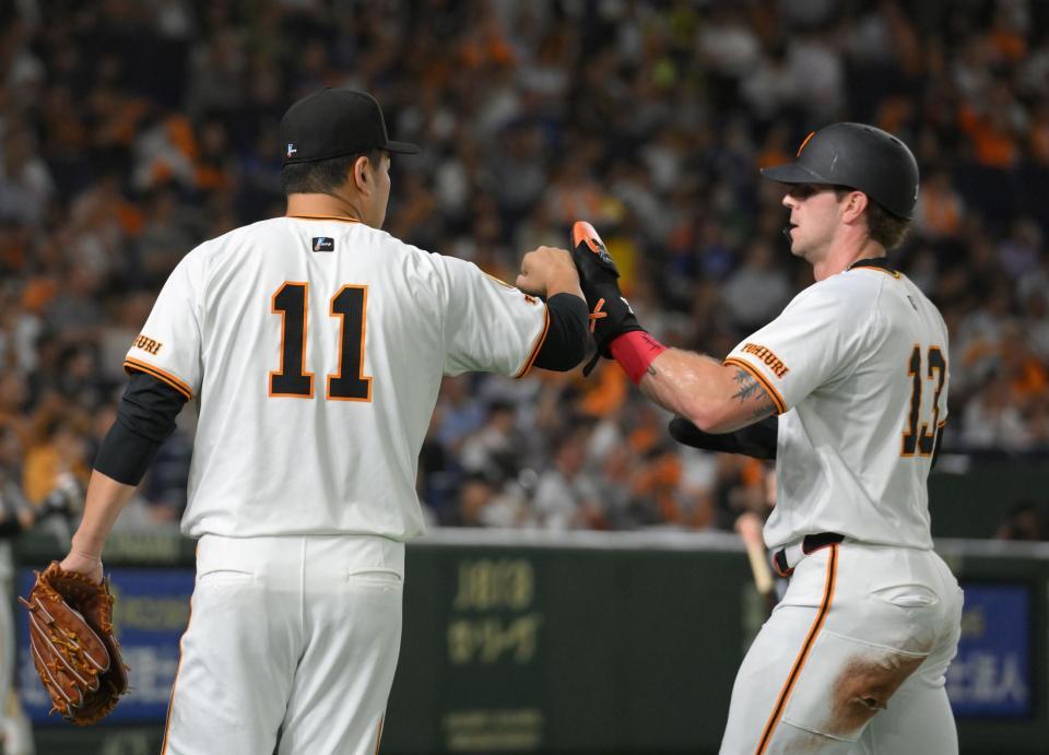 　１回、岡本の右ゴロでアウトになったキャベッジ（右）を迎える田中将（撮影・伊藤笙子）