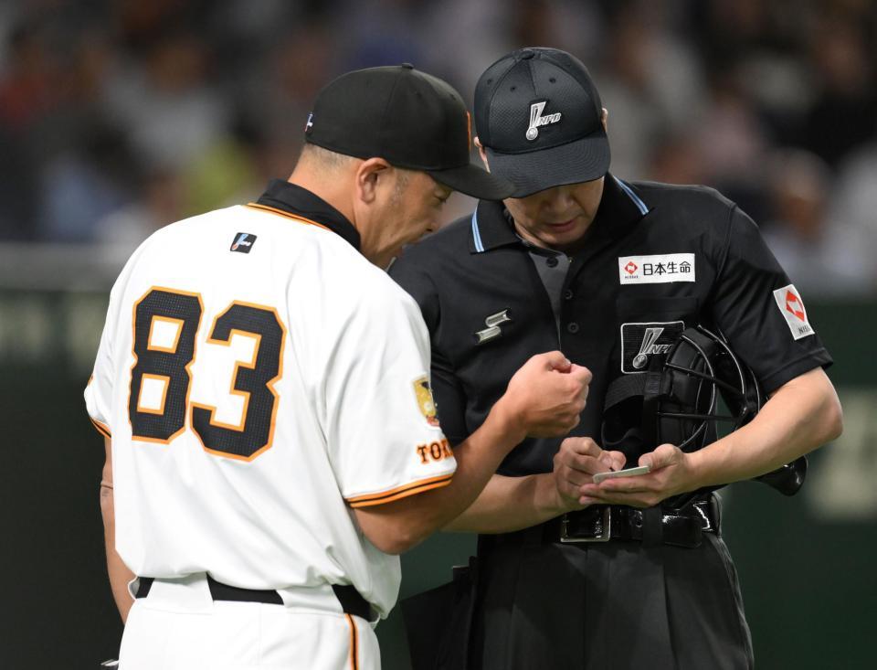 　２回の攻撃を終え、泉口の交代を球審に告げる阿部監督（左）＝撮影・伊藤笙子