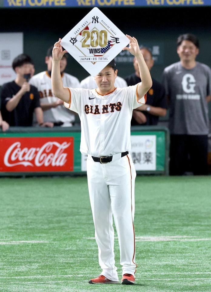 　日米通算２００勝を達成し、ボードを掲げる田中将