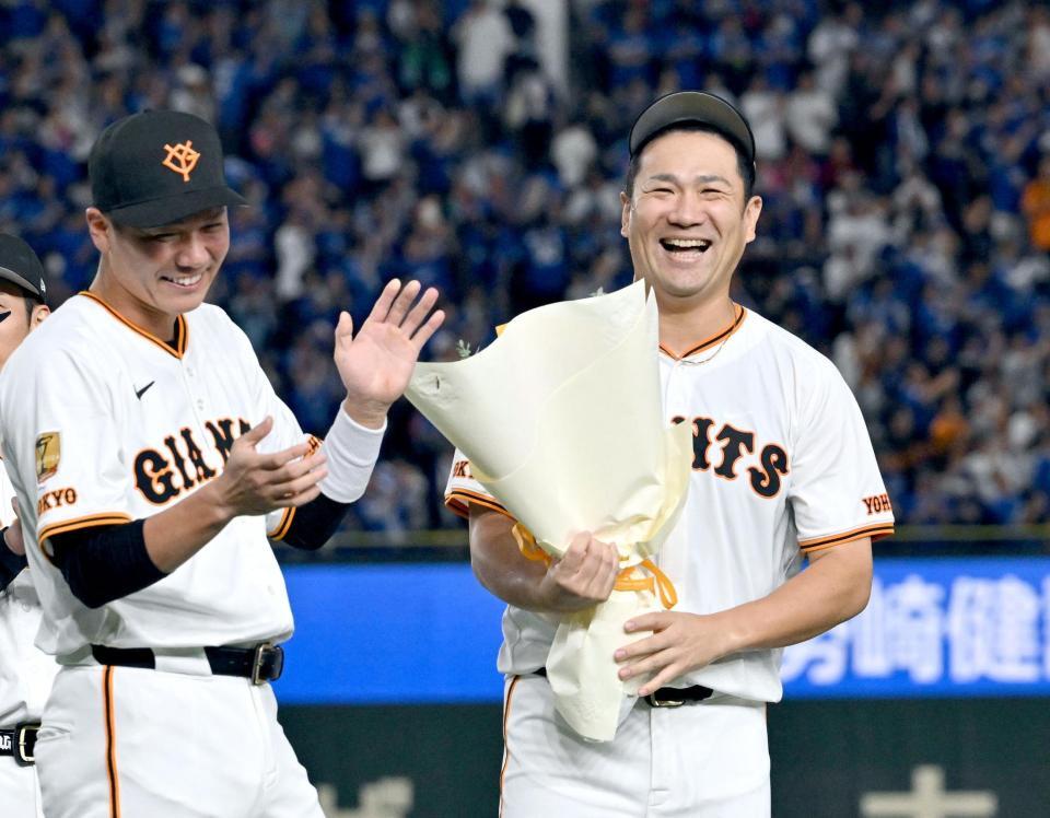 　日米通算２００勝を達成し、坂本（左）から花束を受け取った田中将