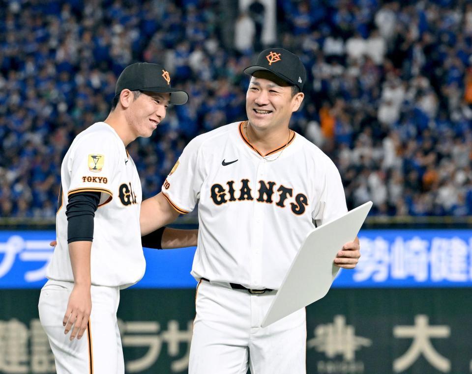 　日米通算２００勝を達成し、戸郷（左）から記念ボードを受け取った田中将
