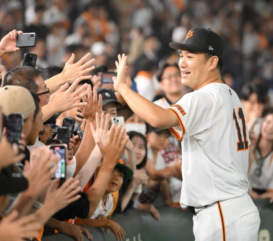 　日米通算２００勝を達成し、ファンとハイタッチする田中将（撮影・伊藤笙子）