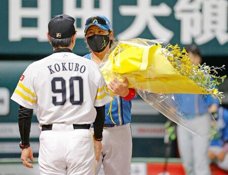 　試合前のメンバー表交換で小久保監督（手前）に花束を贈る新庄監督
