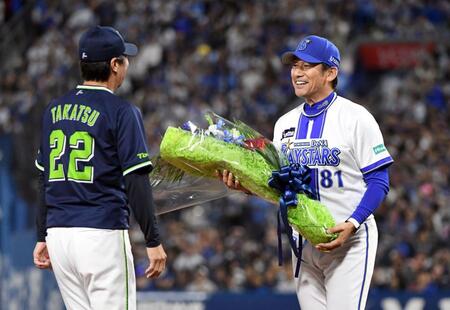 　高津監督（左）に花束を渡す三浦監督（撮影・佐藤厚）