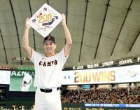 　日米通算２００勝を達成し、ボードを手に笑顔を見せる田中将（撮影・伊藤笙子）