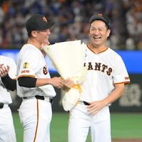　日米通算２００勝を達成し、坂本（左）から記念の花束を受け取る田中将（撮影・伊藤笙子）