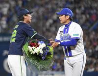 　高津監督（左）に花束を渡す三浦監督（撮影・佐藤厚）