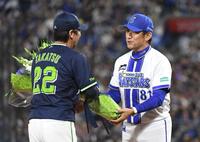 　高津監督（左）に花束を渡す三浦監督（撮影・佐藤厚）