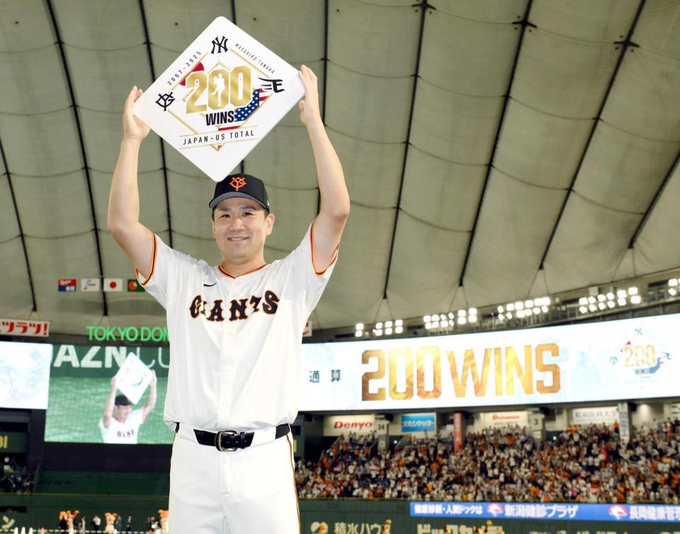 　日米通算２００勝を達成し、ボードを手に笑顔を見せる田中将（撮影・伊藤笙子）