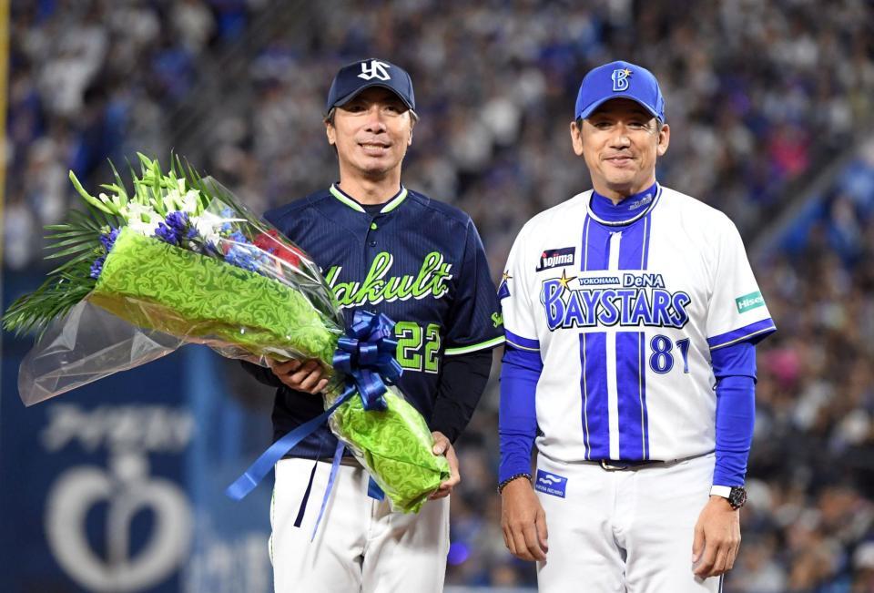 　高津監督（左）に花束を渡した三浦監督（撮影・佐藤厚）