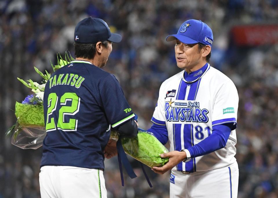 　高津監督（左）に花束を渡す三浦監督（撮影・佐藤厚）