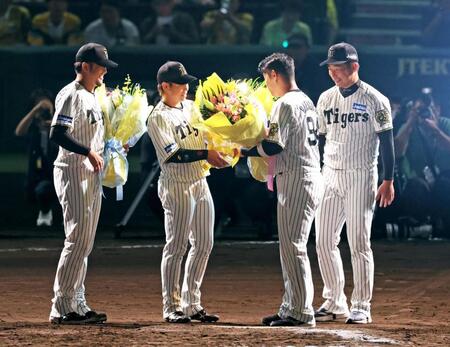 　岩崎（右）、梅野（中央）、岩貞（左）から花束を受け取る原口（撮影・立川洋一郎）