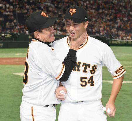 　プロ初勝利を挙げ原監督（左）から手荒い祝福を受け笑顔の直江＝２２年８月
