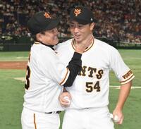 　プロ初勝利を挙げ原監督（左）から手荒い祝福を受け笑顔の直江＝２２年８月