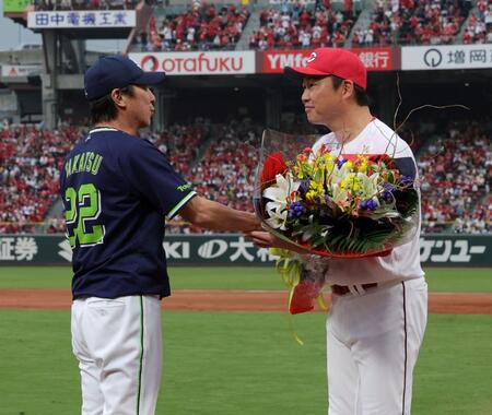 　新井監督から花束を受け取る高津監督（撮影・市尻達拡）