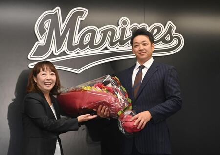 　就任会見で元球団職員の谷保恵美氏（左）から花束を受け取るサブロー新監督（撮影・開出牧）